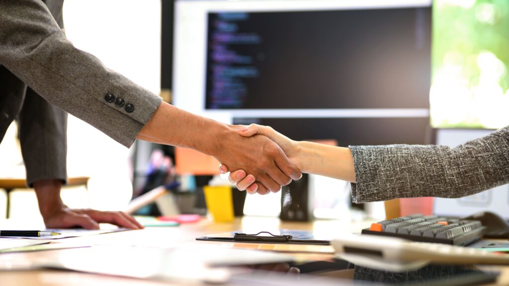 Empresarios cerrando operación de compraventa de empresa con asesoramiento de expertos en M&A